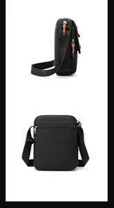 Detail showing the adjustable wide shoulder strap with embossed letters and orange zip pulls