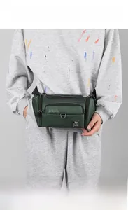 Détail de sac banane en nylon vert foncé avec poches zippées et boucle en anneau en D