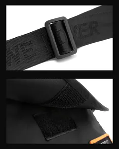 Detail of adjustable shoulder strap with woven lettering and velcro closure on black bag