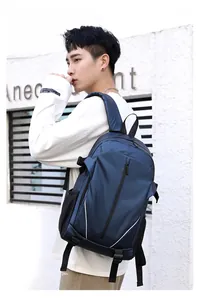 Outdoor shot of a blue water-resistant travel backpack with mesh side pockets on a model