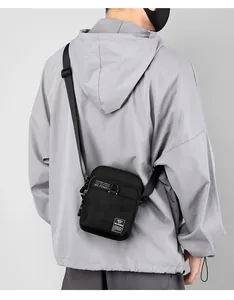 Close-up of black nylon mini crossbody bag showing water-resistant fabric and logo label