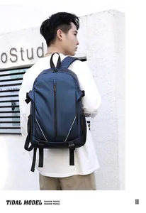 Rear view of man carrying navy blue waterproof backpack with reflective strips