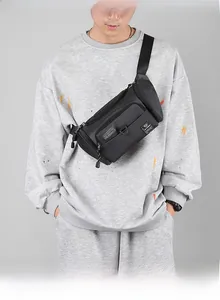 Détail du sac bandoulière en nylon noir avec sangle réglable et plusieurs poches zippées
