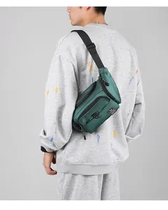 Modèle portant un grand sac bandoulière en nylon vert foncé imperméable à plusieurs poches