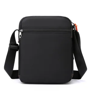 Men's black nylon crossbody bag with orange zipper detail and adjustable strap