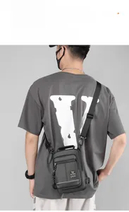 Close-up of gray nylon chest bag with multiple zipper pockets and adjustable strap