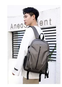 Side view of a grey water-resistant travel backpack with side mesh pockets on a male model
