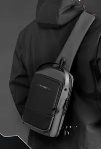 Homme portant un sac de poitrine gris foncé en tissu tech avec large bandoulière