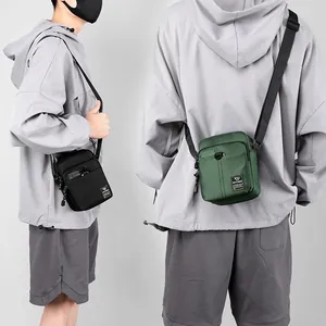Mini nylon crossbody bag for men in black and olive green with adjustable shoulder strap