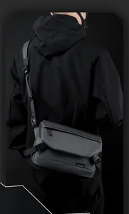 Detailed back view of man wearing a techwear crossbody bag with matte finish and buckle strap