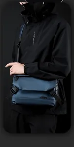 Detail of waterproof nylon crossbody bag featuring secure buckle and brand logo patch