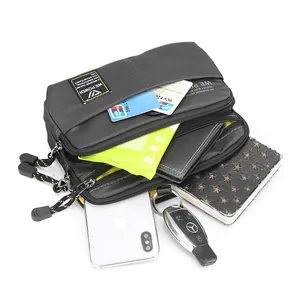 Waterproof dark grey nylon crossbody bag with multiple compartments showing high capacity