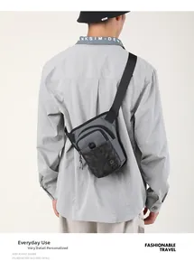 Détail du sac bandoulière fonctionnel gris et noir avec poche camouflage et logo