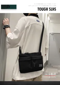 Close-up of black nylon crossbody bag featuring dual zipper pockets and logo detail