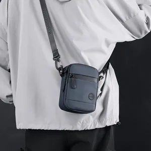 Men's navy nylon crossbody bag featuring waterproof zippers and adjustable logo strap