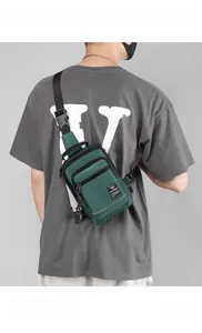 Close-up of waterproof dark green nylon chest bag with adjustable strap and brand tag