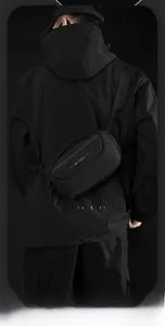 Rear view of a black nylon crossbody chest bag on a model for casual outdoor wear