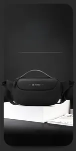 Close-up of minimalist black chest bag with WE POWER logo on a geometric display base
