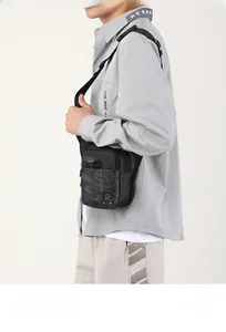 Détail du sac bandoulière camouflage noir pour homme montrant le tissu imperméable