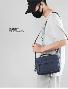 Detail view of large navy blue nylon crossbody bag with adjustable strap and logo