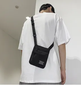 Model trägt eine schmale schwarze Canvas-Umhängetasche zur Darstellung der Passform