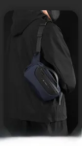 Detail of navy blue crossbody chest bag with adjustable strap on a tactical jacket