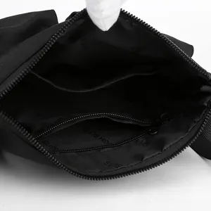 Internal structure of black nylon crossbody bag featuring multi-layer storage and zip pocket