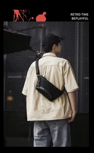 Détail d'un sac bandoulière utilitaire en nylon noir avec motif imprimé mode lettré