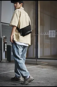 Détail du sac bandoulière tactique en nylon noir avec imprimé mode et sangle réglable
