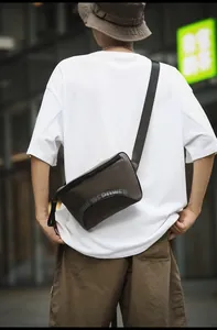 Détail de la bandoulière réglable en nylon noir et fermeture éclair du sac en extérieur