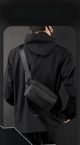 Modern black nylon messenger bag with adjustable wide strap shown in a city style