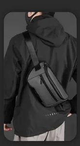 Rear view of a man wearing a dark grey multifunctional nylon crossbody bag for outdoor use