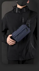Detailed view of deep blue nylon crossbody bag with front zipper and logo on black jacket