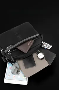 Détail du sac bandoulière noir en nylon montrant la grande capacité pour tablette et objets