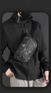Front view of camouflage tactical chest bag with multi-zipper layers on male model