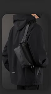 Detail view of the black nylon functional crossbody bag with a circular embossed logo