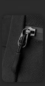 Detail of durable black nylon fabric and metal zipper with non-slip cord on crossbody bag