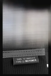 Zoom sur le patch logo et l'étiquette DARE TO INNOVATE d'un sac en nylon noir