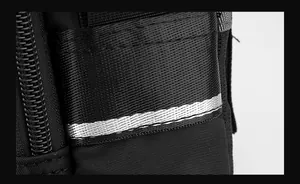 Détail d'un sac bandoulière en nylon avec une bande réfléchissante argentée visible
