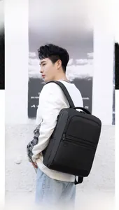 Side view of a black waterproof business laptop backpack worn by a male model outdoors