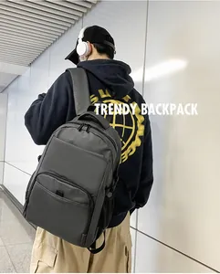 Side view of man carrying a large black nylon business backpack in a modern hallway