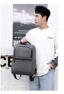 Detail view of water-resistant matte fabric and reinforced handle on dark grey backpack