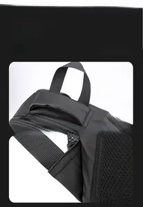 Detail of reinforced triangular stitching and durable top handle on black nylon backpack