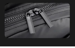 Detailed close-up of the smooth black dual-way resin zipper on the nylon backpack