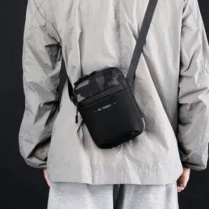Bolso bandolera para hombre en tejido técnico negro con ribete de camuflaje y correa ajustable