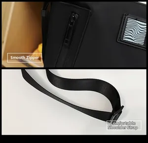 Close-up of smooth metal zippers and durable woven straps on a black nylon crossbody bag