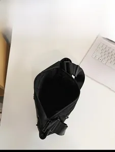 Internal capacity of the black nylon crossbody bag showing spacious main compartment