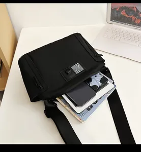 Macro shot of waterproof black crossbody bag with multiple storage layers and D-ring detail