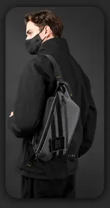 Detail van grijze crossbodytas met duurzame stof en merklogo-patch op de tas