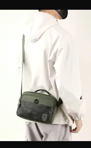 Detail of army green nylon crossbody bag with camouflage pattern and WE POWER logo branding